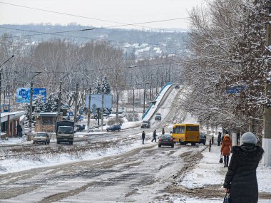 Trafik, kar ve araçlarla dolu işlek bir şehir yolunun kış manzarası, kış veya ilkbahar başında Kostiantynivka, Ukrayna, 01-15-2013