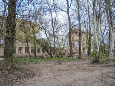 Terkedilmiş, kirli, çıplak dallı ağaçların ve terk edilmiş veya harap olmuş eski bir binanın olduğu, Kostiantynivka, Ukrayna, 01-15-2013