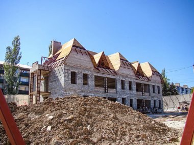 Görüntü, devam eden kazılar ve görünür duvarları olmayan bir inşaat sahasında kısmen inşa edilmiş bir yapıyı tasvir ediyor. Site, diğer Kostiantynivka, Ukrayna, 06-15-2013 ile iyi hava koşulları altında bulunuyor.