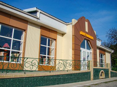 Görüntü, açık havada oturma, geniş pencereler ve Ukrayna, Kostiantynivka, Ukrayna 'daki Brigh Kostiantynivka, 06-15-2013 tarihli Cafe Wien Set yazılı bir giriş tabelasının yer aldığı, kahverengi ve beyaz tonlu modern bir kafe tasvir ediyor.