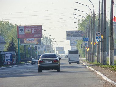Değişen araçlarla şehir caddesi, bulutlu gökyüzü muhtemelen şafak veya alacakaranlık, binalar, tabelalar, sokak lambaları, ağaçlar, reklamlar, trafik işaretleri, hafif trafik işaretleri, Kostiantynivka, Ukrayna, 06-15-2013