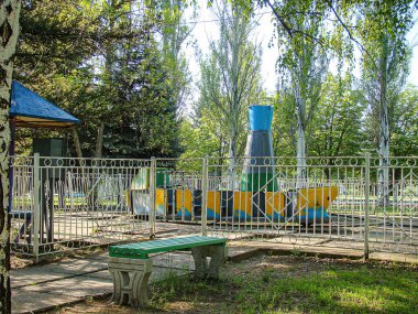 Canlı, çocuk dostu bir açık hava alanı tren şeklinde oyun yapısı, gölgeli bir barınak ve sağlam bir çit kaldırımlı zemin Kostiantynivka, Ukrayna, 06-15-2013