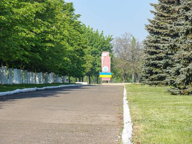 İyi korunmuş asfaltlı bir yol, ağaçlar, çimenli bir alan, hareket bulanıklığı, bulutlu gökyüzü ve kısmen karanlık bir rec Kostiantynivka, Ukrayna, 06-15-2013