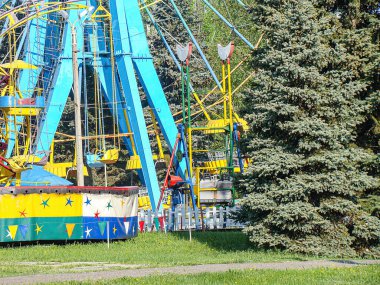 Görüntü durgun bir atlıkarınca tasvir ediyor, binicili ya da binicisiz renkli atlar, yeşil bir park alanında hiç kimse Kostiantynivka, Ukrayna, 06-15-2013
