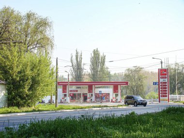 Kırmızı bir bina, çeşitli araçlar, yemyeşil yemyeşil ve mavi gökyüzü Kostiantynivka, Ukrayna, 06-15-2013