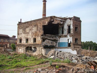 Çürüme ve hasar izleri olan terk edilmiş bir sanayi binası dağınık döküntüler, açık iç unsurlar, ihlal edilen bitki örtüsü kısmen çökmüş Kostiantynivka, Ukrayna, 06-15-2013