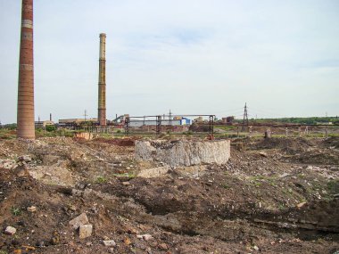 Görüntü, enkaz, yüksek bacalar ve seyrek bitki örtüsüyle terk edilmiş bir sanayi manzarasını tasvir ediyor. Sahne, Kostiantynivka, Ukrayna 'nın, 06-15-2013 tarihli
