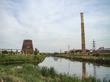 Terk edilmiş bir endüstriyel yapıya sahip doğal bir manzara, gün ışığında yumuşak ışık ve uzun gölgelerle çekilmiş Kostiantynivka, Ukrayna, 06-15-2013