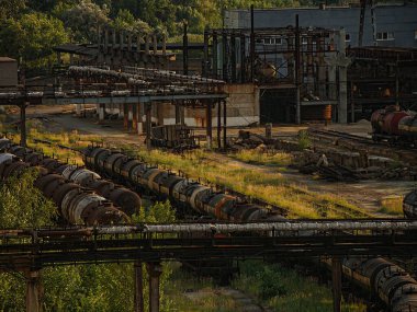 Paslı metal yapılara sahip terk edilmiş sanayi bölgesi, bitki örtüsüyle kaplı, doğal ıslah edilmemiş toprak kalıntılarla kaplı sıcak hava ve Kostiantynivka, Ukrayna, 06-15-2013