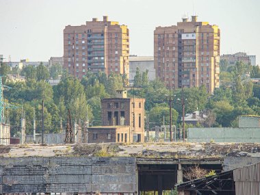 Kentsel manzaranın panoramik görüntüsü aşırı büyümüş çimenler, yapıların kalıntıları ve orta zemindeki belirgin tuğla bacası Uzak Kostiantynivka, Ukrayna, 06-15-2013