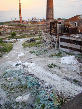 Görüntü, harap olmuş beton ve metal bir bina, enkaz, çöp yığını, kırık pencereler, bulutlu gökyüzü, duman yığınları ve pow Kostiantynivka, Ukrayna, 06-15-2013