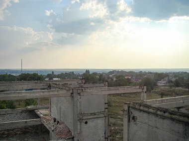 Terk edilmiş beton binanın görüntüsü aşınma izleri, kayıp çatı bölümleri ve bitki örtüsü büyümesini gösteriyor. Bina diğer Kostiantynivka, Ukrayna, 06-15-2013