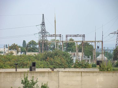 Ukrayna, Kostiantynivka, Ukrayna 'da bulutlu bir gökyüzü altında trafolar, kablolar ve bitki örtüsü bulunan bir elektrik santraline odaklanan endüstriyel bir sahne, 06-15-2013
