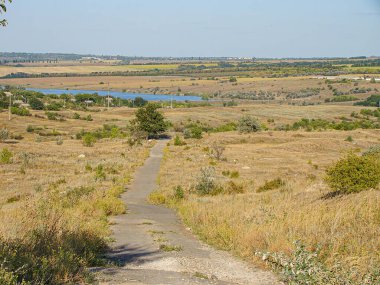 Düşük tepeler ve kuru bitki örtüsü ile karakterize edilen, geniş, kurak bir arazi yumuşak ışık sağlıyor, Kostiantynivka, Ukrayna, 06-15-2013