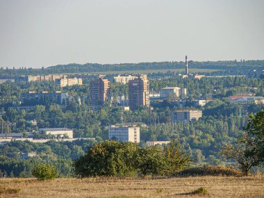 Panoramik şehir manzarası, parkın doğal zeminine göre değişen yükseklik ve tasarımlara sahip binaların bir karışımını içerir. Açık gökyüzü Kostiantynivka, Ukrayna, 06-15-2013