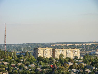 Yeşil ağaçlar, mütevazı evler, çok katlı konutlar, bulutlu gökyüzü ve renkli Kostiantynivka, Ukrayna, 06-15-2013