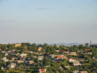 Ukrayna 'nın Kostiantynivka kentindeki kırmızı ve gri konut binaları, ağaçlarla kaplı tepeler, 06-15-2013 tarihli yoğun bir Avrupa tarzı kentsel alanın panoramik bir öğleden sonra veya akşam manzarası