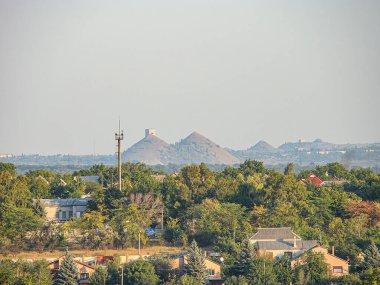 Şehirdeki yemyeşil tepeler ve uzaktaki konut, ticari ve sanayi binalarının karışımından oluşan panoramik manzara Ukrayna, Kostiantynivka, Ukrayna 'da sunuluyor, 06-15-2013