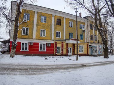 Kışın gri bulutlu gökyüzü Kostiantynivka, Ukrayna, 01-15-2013 'te karlı, iki katlı sarı ve kırmızı yerleşim yeri görüntüsü