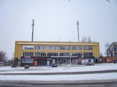 Kışın kar, park halindeki arabalar, bulutlu gökyüzü ve binadaki bulanık kaliteli metin görüntüsü, Angleresolu Kostiantynivka, Ukrayna, 01-15-2013