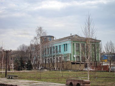 İki katlı bir bina yenileniyor, üst kısmı açık yeşil, alt kısmı ise aşınmış camlar, iskele iskelesi Kostiantynivka, Ukrayna, 06-15-2013