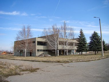 Düz çatısı, görünür pencereleri ve önünde boş otlağı olan modern, çok katlı bir konut binası. Sahne, Ukrayna 'nın güneşli bir günü olduğunu gösteriyor. 01-15-2013