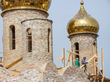 Görüntü, biri desenli yüzeyi ve kubbeli, karmaşık dizayn ve altın aksanlı, Kostiantynivka, Ukrayna, 01-15-2013 tarihli iki yapıya sahip bir inşaat alanını gösteriyor.