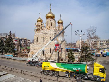 Görüntü, büyük, süslü bir binanın bulunduğu bir şehir sahnesini tasvir ediyor. Muhtemelen bir cami veya dini yapı bakımını üstlenen bir gökyüzü, uzun vinç, Kostiantynivka, Ukrayna, 01-15-2013