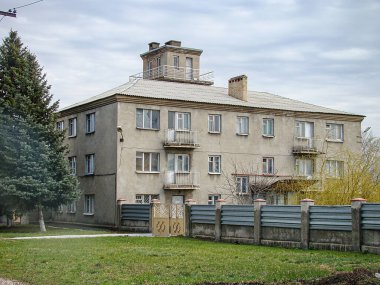 Beton çitlerle çevrili çok katlı bir apartman kompleksi. Binanın bacası var ve muhtemelen sonbaharda veya w Kostiantynivka, Ukrayna, 01-15-2013