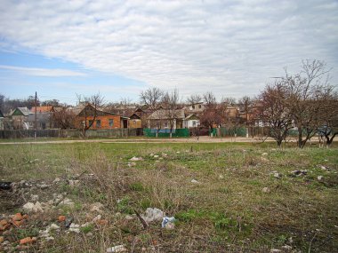 Görüntü yıkık dökük binalar, molozlar, yabani otlar ve hiçbir insan aktivitesinin olmadığı felaket dolu bir yerleşim alanı gösteriyor. Gökyüzü ihmal veya terk edilme, Kostiantynivka, Ukrayna, 01-15-2013