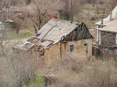 Görüntü, yıkık dökük binalar ve çıplak ağaçlarla kışın veya ilkbaharın başında binaların yıkık dökük olduğunu gösteriyor. Ne Kostiantynivka, Ukrayna, 01-15-2013