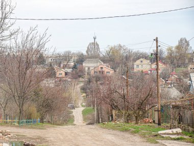 Görüntü, muhtemelen sonbahar veya kış aylarında Avrupa 'da bir tepe üzerinde bir kilise bulunan bir yerleşim alanı gösteriyor. Sahnede elektrik hatları, elektrik direkleri ve Aziz Kostiantynivka, Ukrayna, 01-15-2013