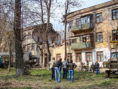 Yıkılmış bir şehir manzarası yangın veya patlamadan kaynaklanan hasarı gösteriyor, enkaz ve yıkık dökük binalarla insanlar hasarı inceliyor, bir kayıt Greenery, Kostiantynivka, Ukrayna, 01-15-2013