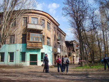 Görüntü, eski bir ilçede muhtemelen tadilat veya onarım gerektiren kısmen hasarlı bir şehir konut binasını gösteriyor. İnsanlar binayı Ukrayna, Kostiantynivka, 01-15-2013