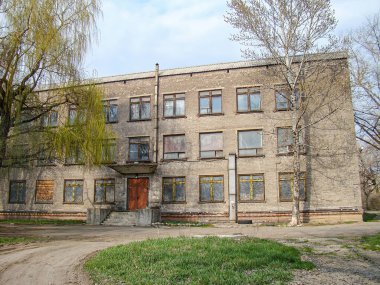 Simetrik cepheli ve düz çatılı yıpranmış, çok katlı bir tuğla bina şehir veya banliyö ortamında resmedilmiş. Görüntü Wor Kostiantynivka, Ukrayna, 01-15-2013