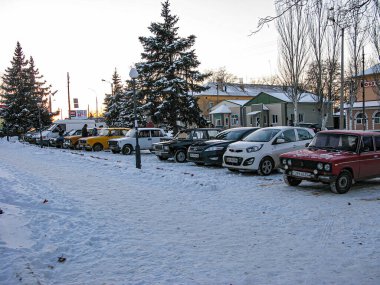 Kuzey Avrupa ya da Kuzey Amerika 'da 30 Kasım 2016' da çekilmiş park halindeki arabaların olduğu karlı bir sokak sahnesi. Görüntü, biz Kostiantynivka, Ukrayna, 01-15-2013 'teki bulutlu kışı gösteriyor.