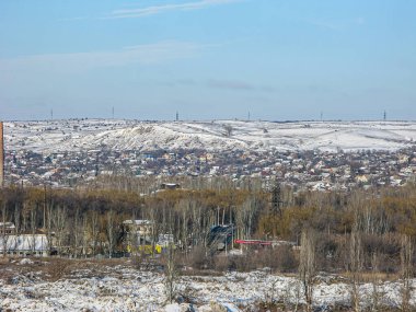 Karla kaplı bir kış manzarası, çıplak ağaçlar, evler, tepeler veya alçak dağlar, bulutlu gökyüzü Kostiantynivka, Ukrayna, 01-15-2013