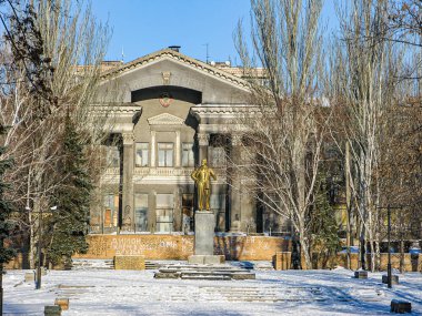 Karla kaplı zeminde Kostiantynivka, Ukrayna 'da 01-15-2013 tarihli merkezi heykeli olan, kış arkaplanına karşı büyük bir neoklasik bina.