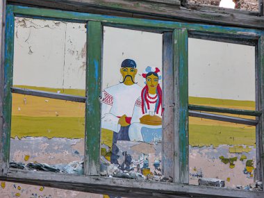 Resim, duvarında iki figürü tasvir eden çocuksu bir el resmi olan eski, harap bir odanın fotoğrafı. Bir figür koyu renk saçlı ve bir Kostiantynivka, Ukrayna, 01-15-2013