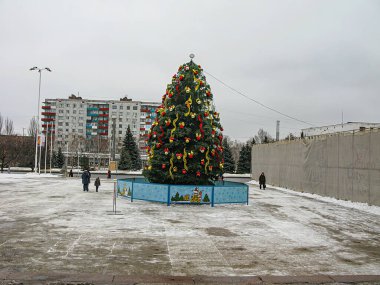 Bir kış kenti ortamında dışarıda bir Noel ağacı sergileniyor, yerde kar ve soğuk, bulutlu hava koşulları bireyler etrafında toplanıyor, bu da bunun bir pu Kostiantynivka, Ukrayna, 01-15-2013