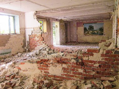 Bir fotoğraf enkazla harap olmuş bir binanın içini yakalıyor, tuğla duvarlar hasar gösteriyor, asılı bir resim, tavandan süzülen doğal ışık, openi Kostiantynivka, Ukrayna, 06-15-2013
