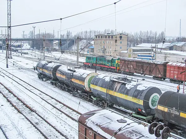 Görüntü, iki lokomotif ve tren vagonu da dahil olmak üzere birden fazla treni olan karlı bir tren istasyonu gösteriyor. Biri dizel elektrikli, diğeri ise s Kostiantynivka, Ukrayna, 01-15-2013 nedeniyle belirsiz.