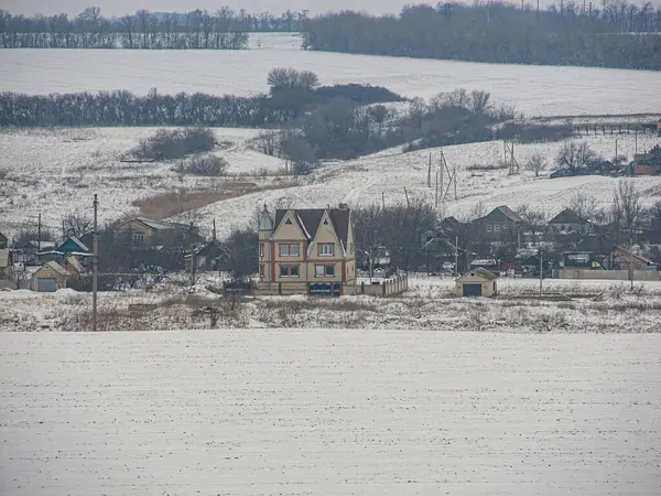 Karlı kırsal bir arazide eski bir 19. yüzyıl binası birden fazla pencere ve yurt penceresi ile çevrili yol ağları, çıplak ağaçlar, sn Kostiantynivka, Ukrayna, 01-15-2013
