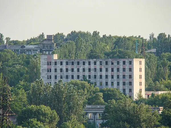 Kostiantynivka, Ukrayna 'da pencereleri, balkonları ve kısmen temiz gökyüzünü çevreleyen yeşillikleri olan çok katlı beton bir binanın havadan görünüşü, 06-15-2013