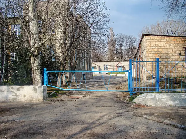 Görüntü, çıplak ağaçlar ve temiz gökyüzü ile çevrili bir bina veya enstitüye giden bir merdivenle kent manzarasını tasvir ediyor. Yapının beton duvarları, rüzgarı Kostiantynivka, Ukrayna, 01-15-2013