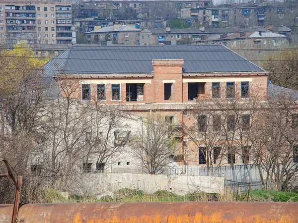 Görüntü, inşaat veya yenilenme aşamasındaki çok katlı bir binayı, tuğla ve beton elementlerle birlikte gösteriyor. Sahne, Kostiantynivka, Ukrayna 'daki diğer binalarla birlikte kentsel, 01-15-2013