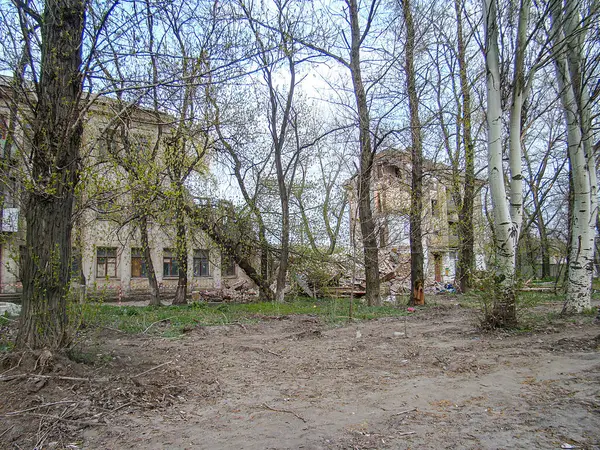 Terkedilmiş, kirli, çıplak dallı ağaçların ve terk edilmiş veya harap olmuş eski bir binanın olduğu, Kostiantynivka, Ukrayna, 01-15-2013