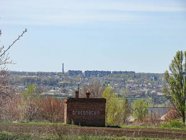 Kostiantynivka, Ukrayna 'da bir kentsel alanın ipuçlarına sahip, sonbahar ağaçları ve bulutlu gökyüzü ile çevrili, muhtemelen tarihi bir tuğla bina, 06-15-2013