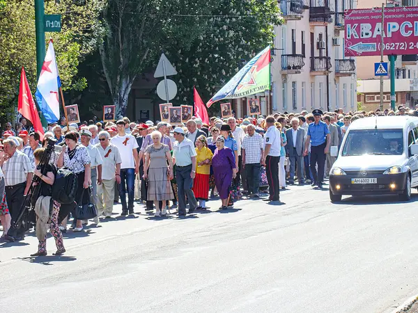 Kentsel bir siyasi mitingde bayraklar ve pankartlar taşıyan farklı bir kalabalığın samimi bir fotoğrafı. Kurulum, binaların, kablolar, Kostiantynivka, Ukrayna, 06-15-2013