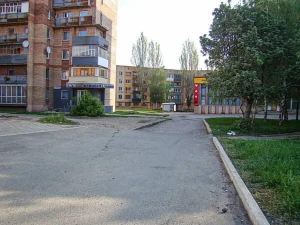 Görüntü, sola dönük binalarla çevrili, muhtemelen konut veya ticari ve sarı bir yapı işletmesi olan Kostiantynivka, Ukrayna, 06-15-2013